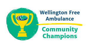 A trophy with a cross on it against a green background and text: Wellington Free Ambulance Community Champions