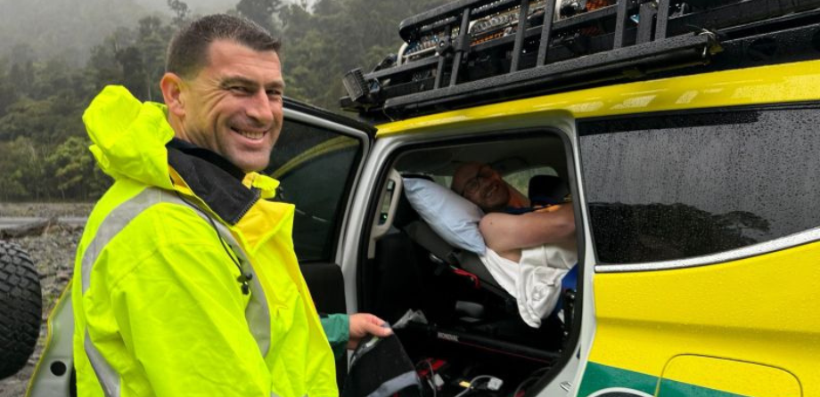 A paramedic in a hi vis jacket smiles