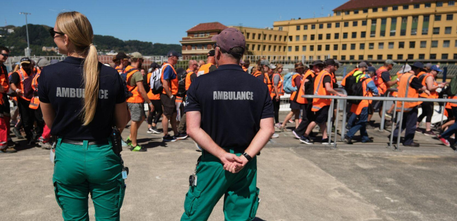 Backs of 2 people with the word ambulance written on them